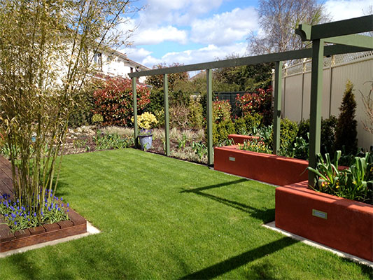 The use of a pergola lends strong lines to the design and draws the eye across the garden