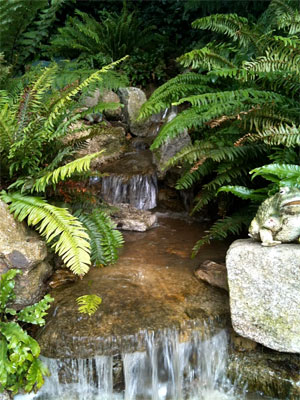 This water feature runs over boulders nestled in planting for a natural stream finish