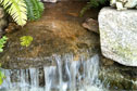 This water feature runs over boulders nestled in planting for a natural stream finish.